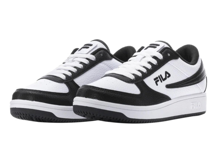 Tenis FILA de corte bajo en colores blanco y negro con suela blanca y base negra.