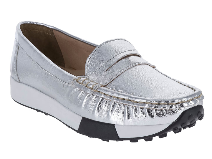 Zapato tipo mocasín color plata metálico con suela blanca y negra.