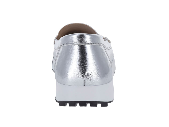 Zapato tipo mocasín color plata metálico con suela blanca y negra.