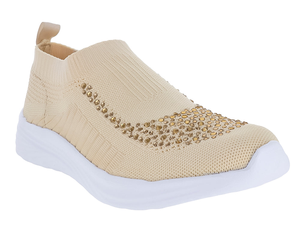 Tenis deportivos Nomadas color beige hueso con detalles brillantes en la parte frontal y suela blanca.