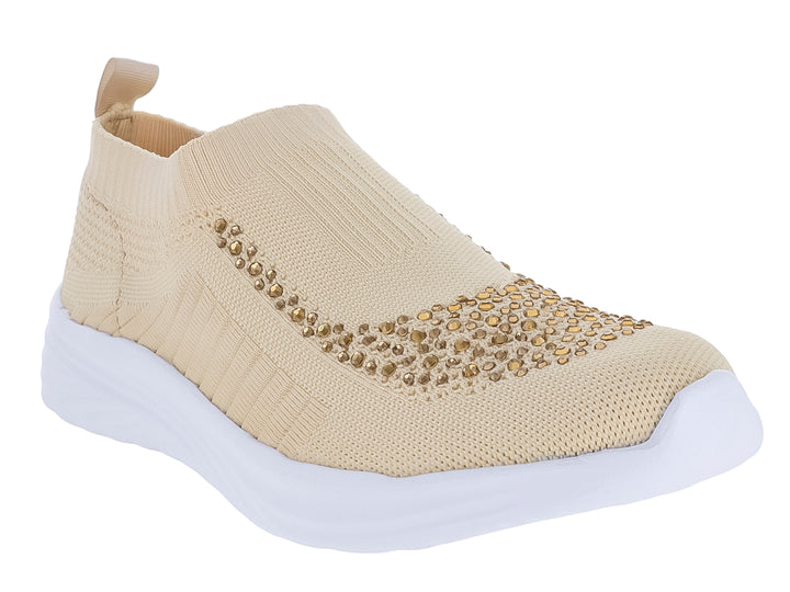 Tenis deportivos Nomadas color beige hueso con detalles brillantes en la parte frontal y suela blanca.