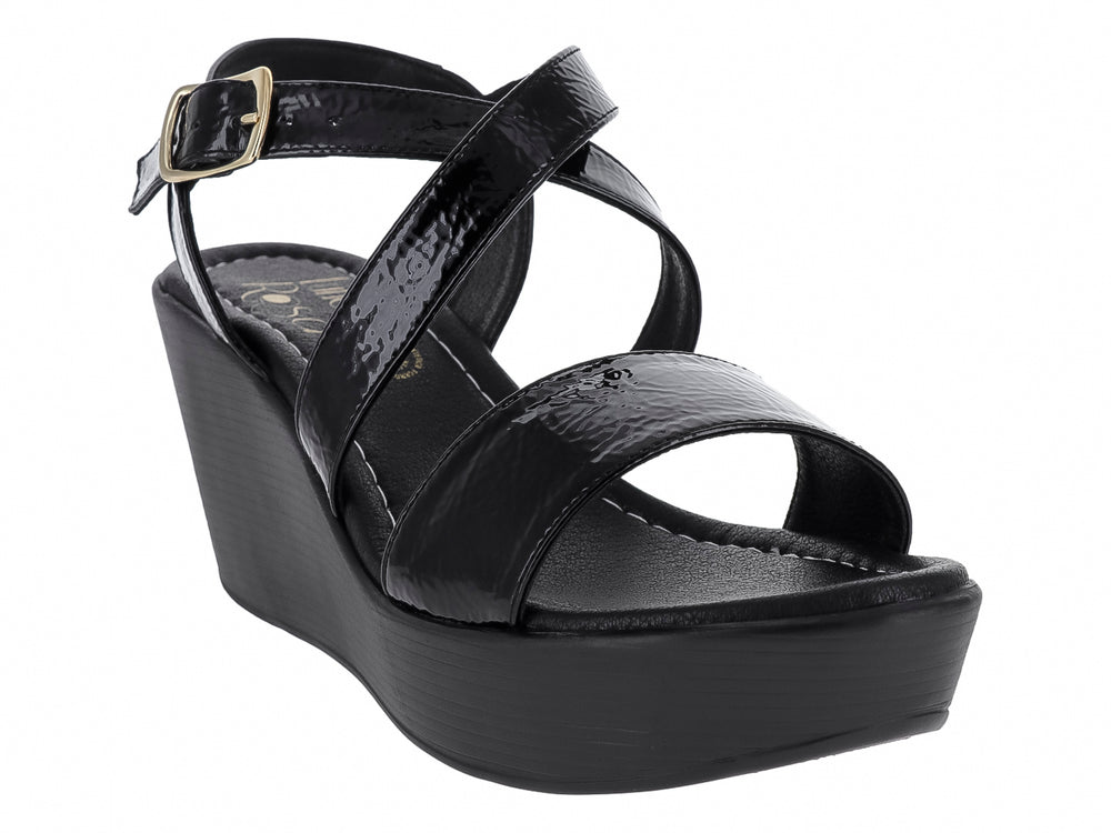 Sandalia de cuña color negro con tiras de charol brillante y hebilla dorada.