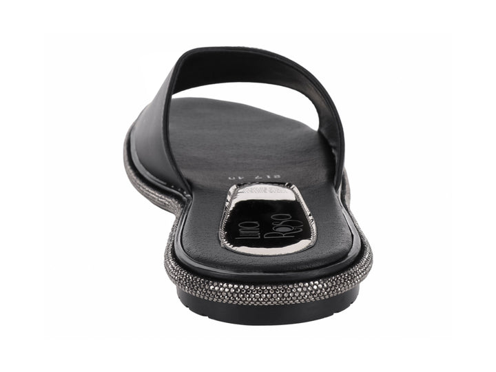 Sandalia negra para mujer con banda ancha decorada con pedrería plateada y suela brillante.