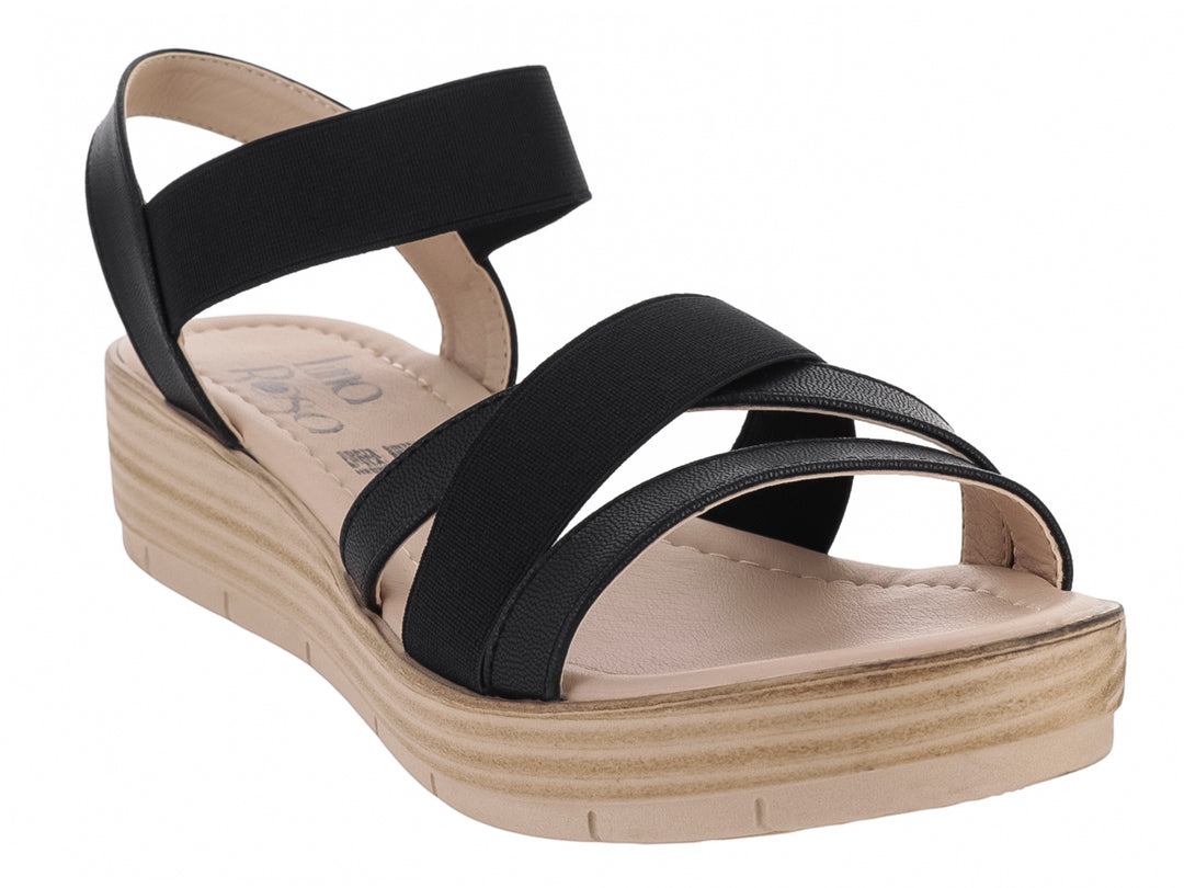 Sandalia de plataforma color negro con suela beige y tiras cruzadas.