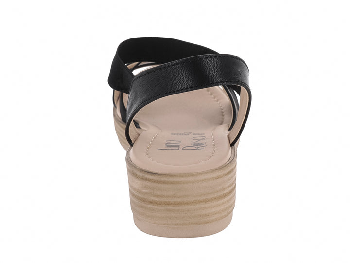 Sandalia de plataforma color negro con suela beige y tiras cruzadas.
