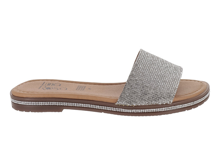 Sandalia plana para niña en color plata brillante con suela marrón.