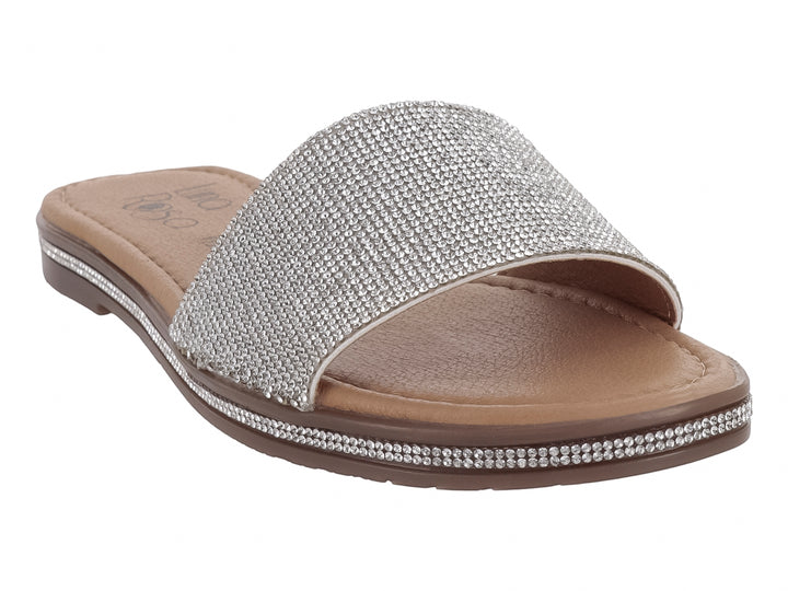 Sandalia plana para niña en color plata brillante con suela marrón.
