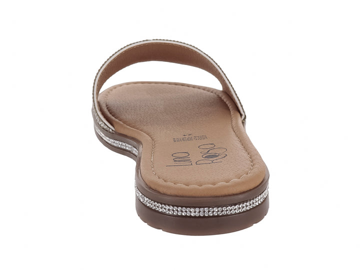 Sandalia plana para niña en color plata brillante con suela marrón.