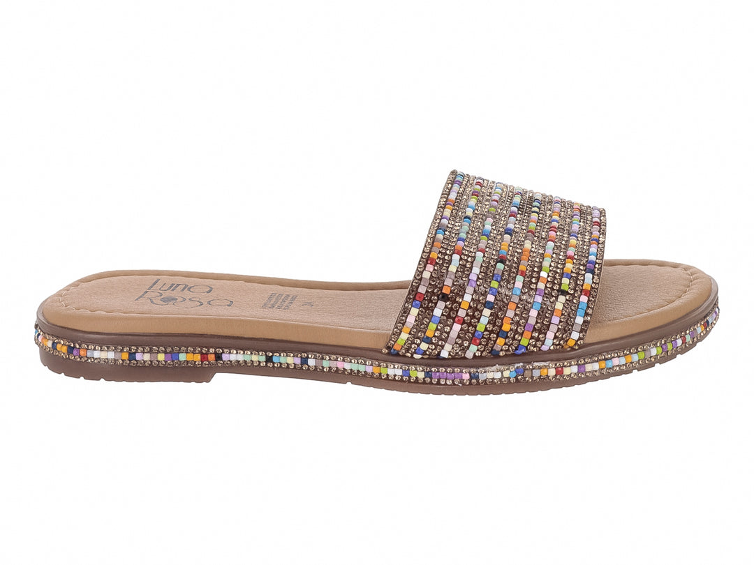 Sandalia plana multicolor con banda superior y borde de suela decorados con pequeñas cuentas multicolores sobre base beige.