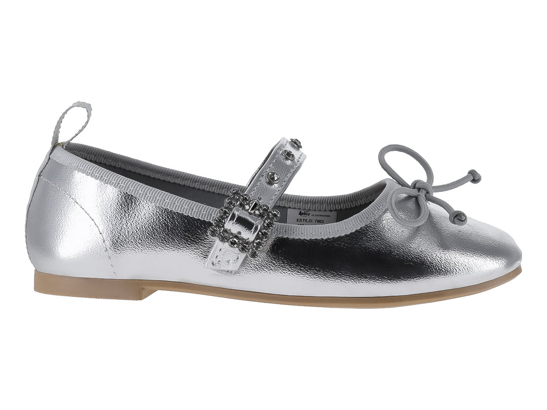Zapato plano plateado brillante para niña con correa y moño decorativo.