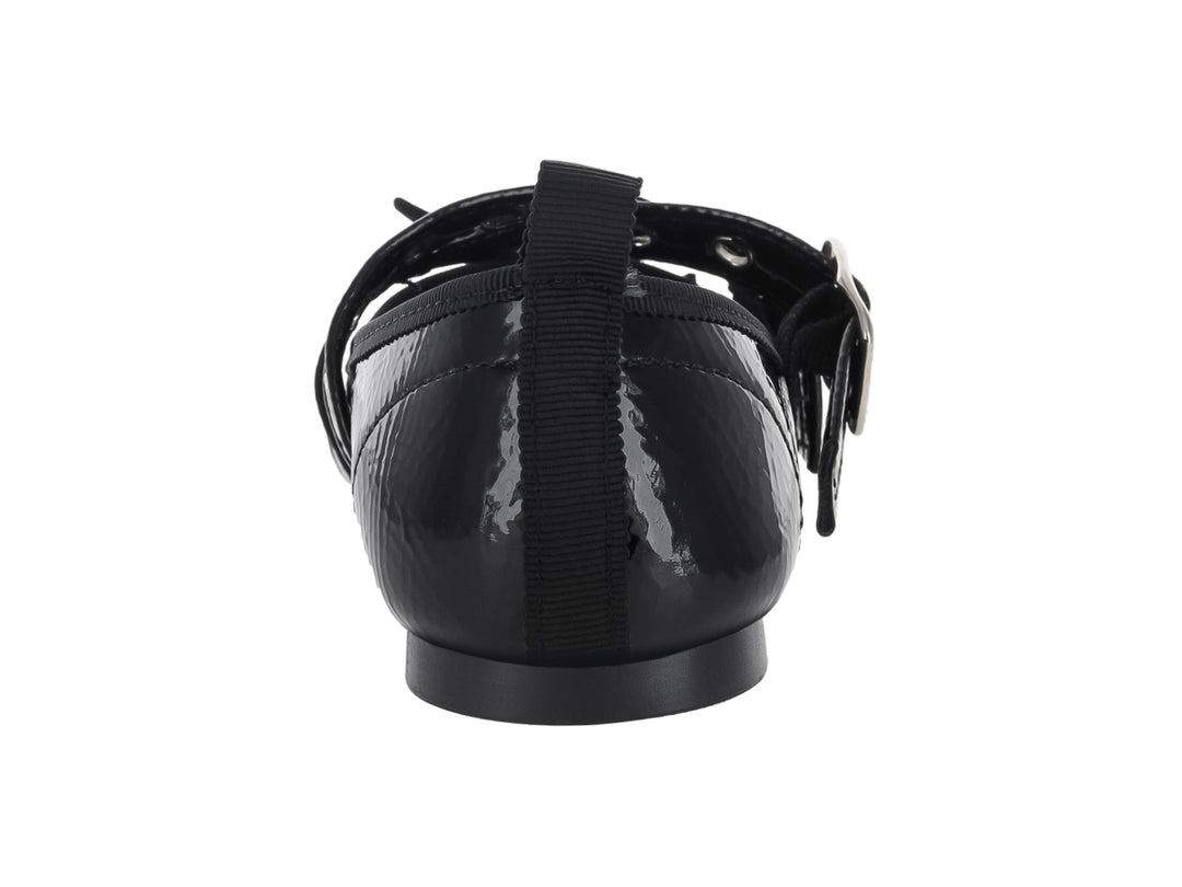 Zapato plano de charol negro con dos hebillas plateadas y un moño decorativo en la punta.
