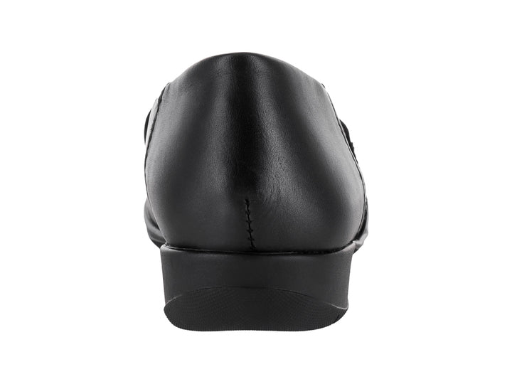 Zapato negro para niña marca Flexi con correa ajustable y detalle de flor en la punta.