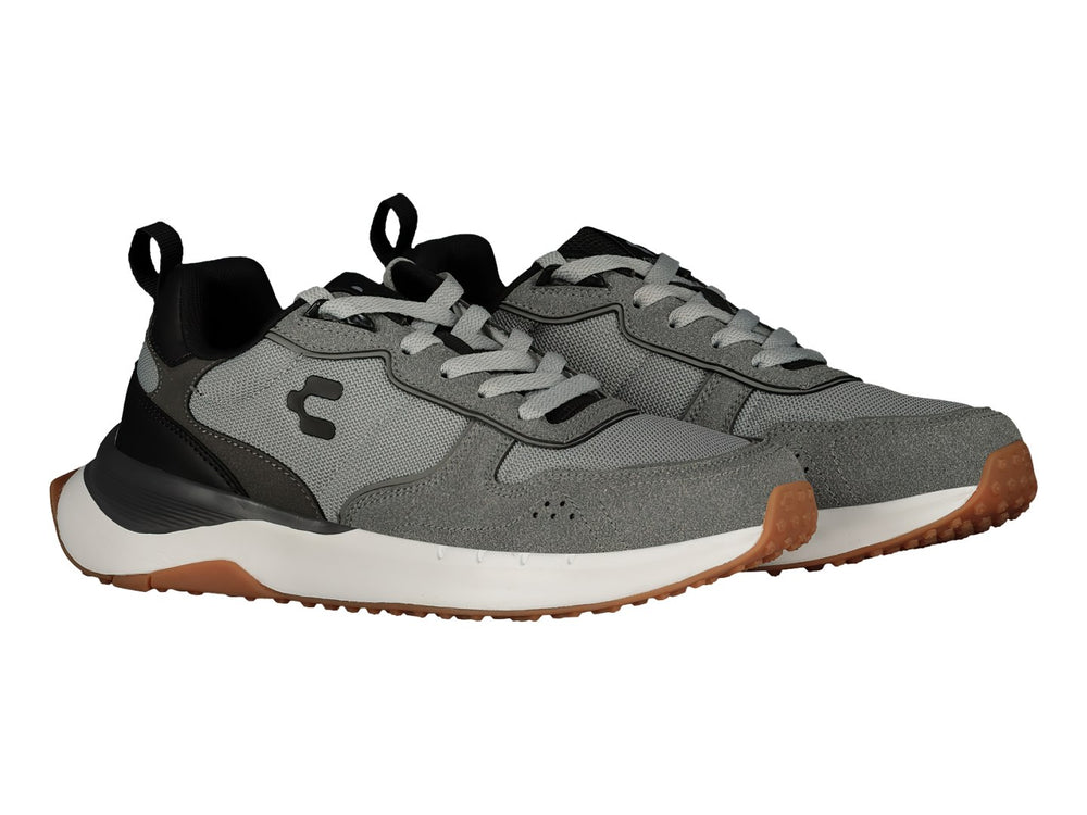 Tenis deportivos Charly color gris Oxford con detalles en negro, suela blanca y base café.