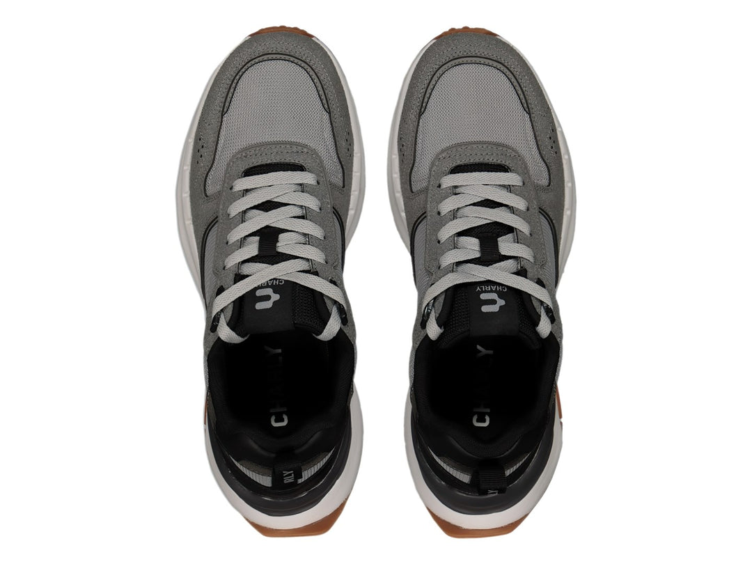 Tenis deportivos Charly color gris Oxford con detalles en negro, suela blanca y base café.