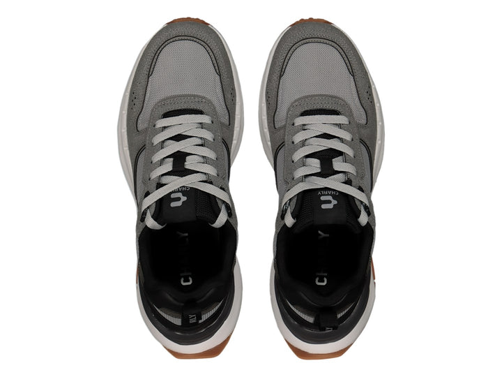 Tenis deportivos Charly color gris Oxford con detalles en negro, suela blanca y base café.