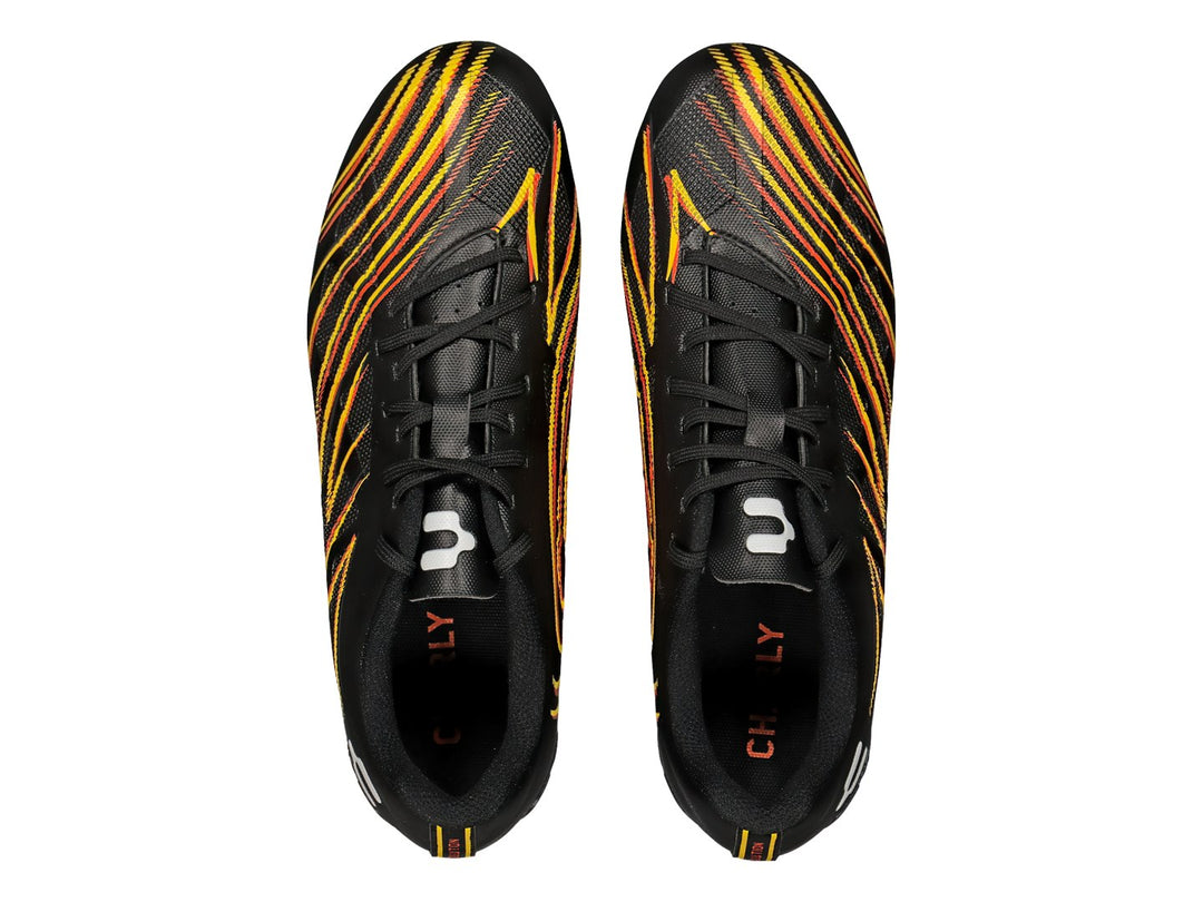 Calzado de fútbol Charly negro con diseño de llamas en naranja y amarillo y tacos naranjas.
