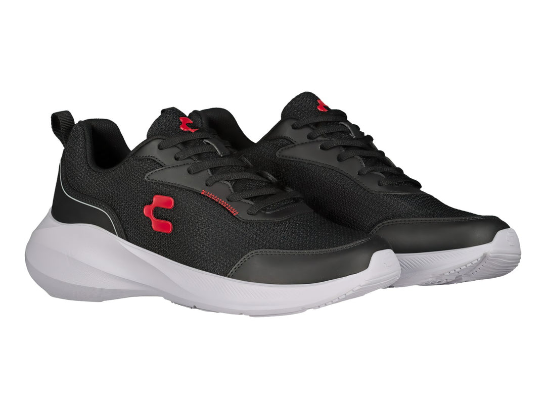 Tenis deportivos Charly en color negro con suela blanca y detalles rojos, vista lateral.