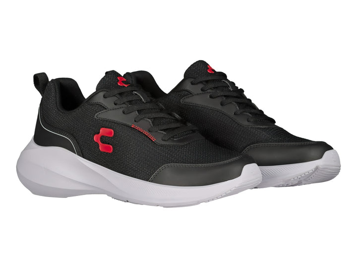Tenis deportivos Charly en color negro con suela blanca y detalles rojos, vista lateral.