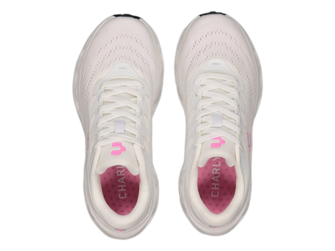 Tenis deportivos Charly color blanco con detalles en rosa y suela blanca con perforaciones laterales.