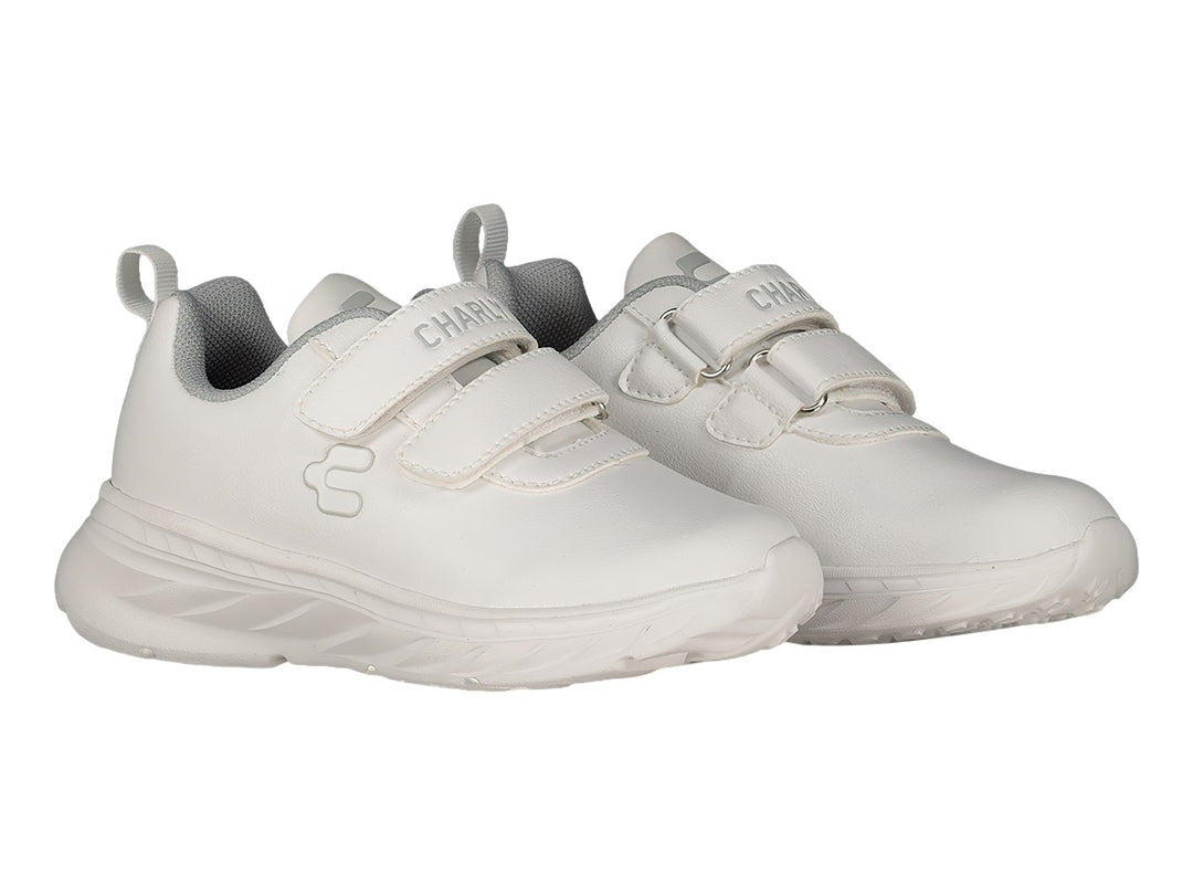 Tenis deportivos blancos de la marca Charly con cierre de velcro y suela gruesa.