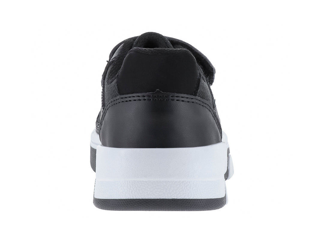 Zapato infantil color negro con suela blanca y cierre de velcro.