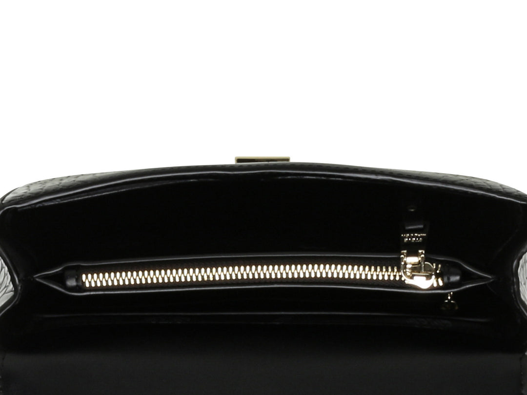 Bolso pequeño negro de Steve Madden con textura de cocodrilo y correa de cadena dorada.