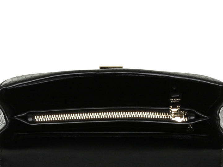 Bolso pequeño negro de Steve Madden con textura de cocodrilo y correa de cadena dorada.