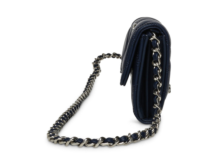 Bolso de hombro Steve Madden color azul marino con textura acolchada y correa de cadena plateada.
