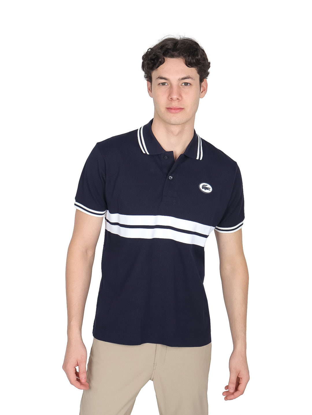 Hombre vistiendo polo Lacoste azul marino con rayas blancas horizontales y detalles en blanco en cuello y mangas.