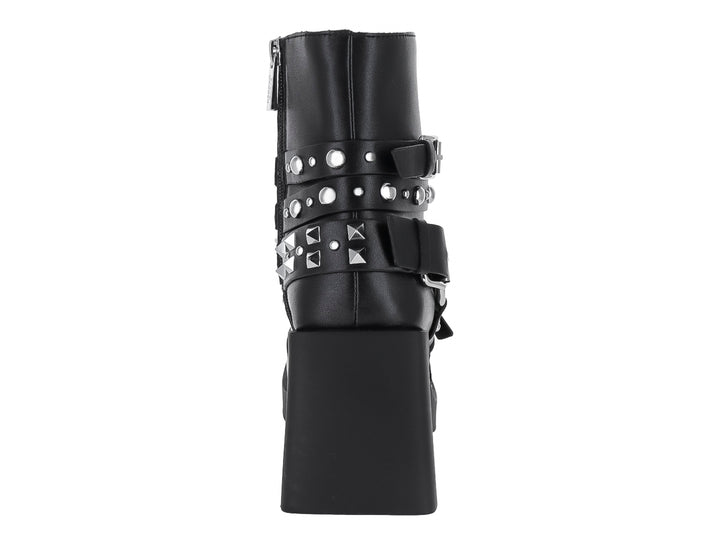 Bota negra de cuero con plataforma, tacón grueso y correas con hebillas y estoperoles plateados.