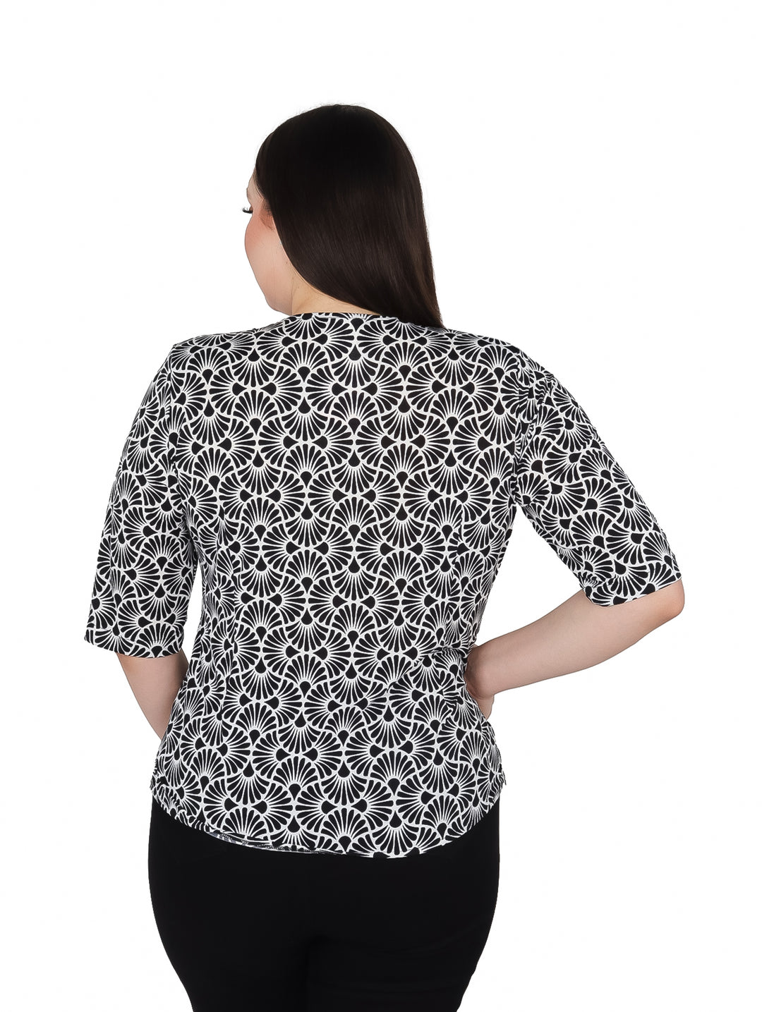 Mujer vistiendo blusa de licra estampada en blanco y negro con manga 3/4 y cuello en V.