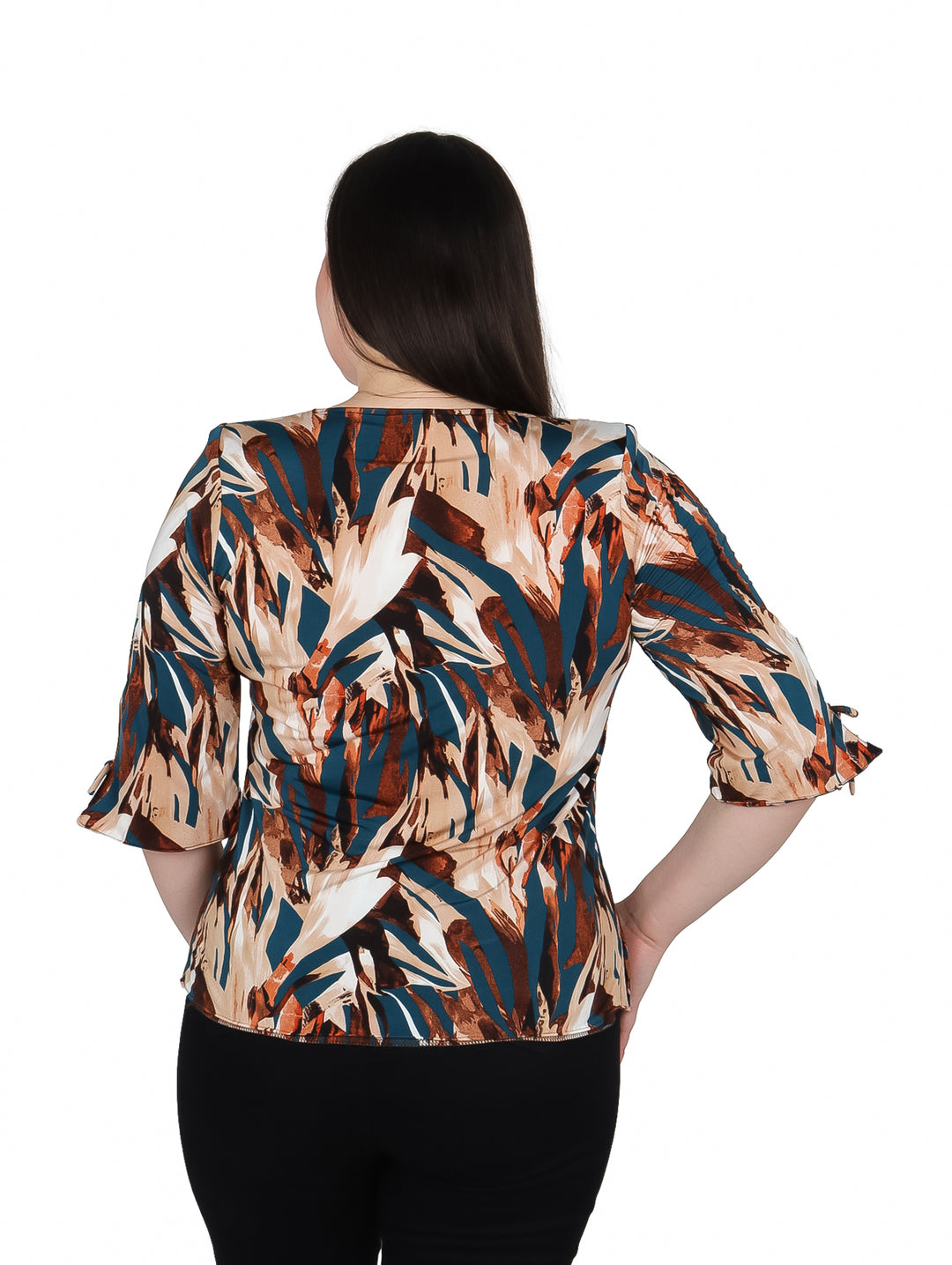 Mujer vistiendo blusa de licra estampada en tonos café, azul y blanco con collar integrado.