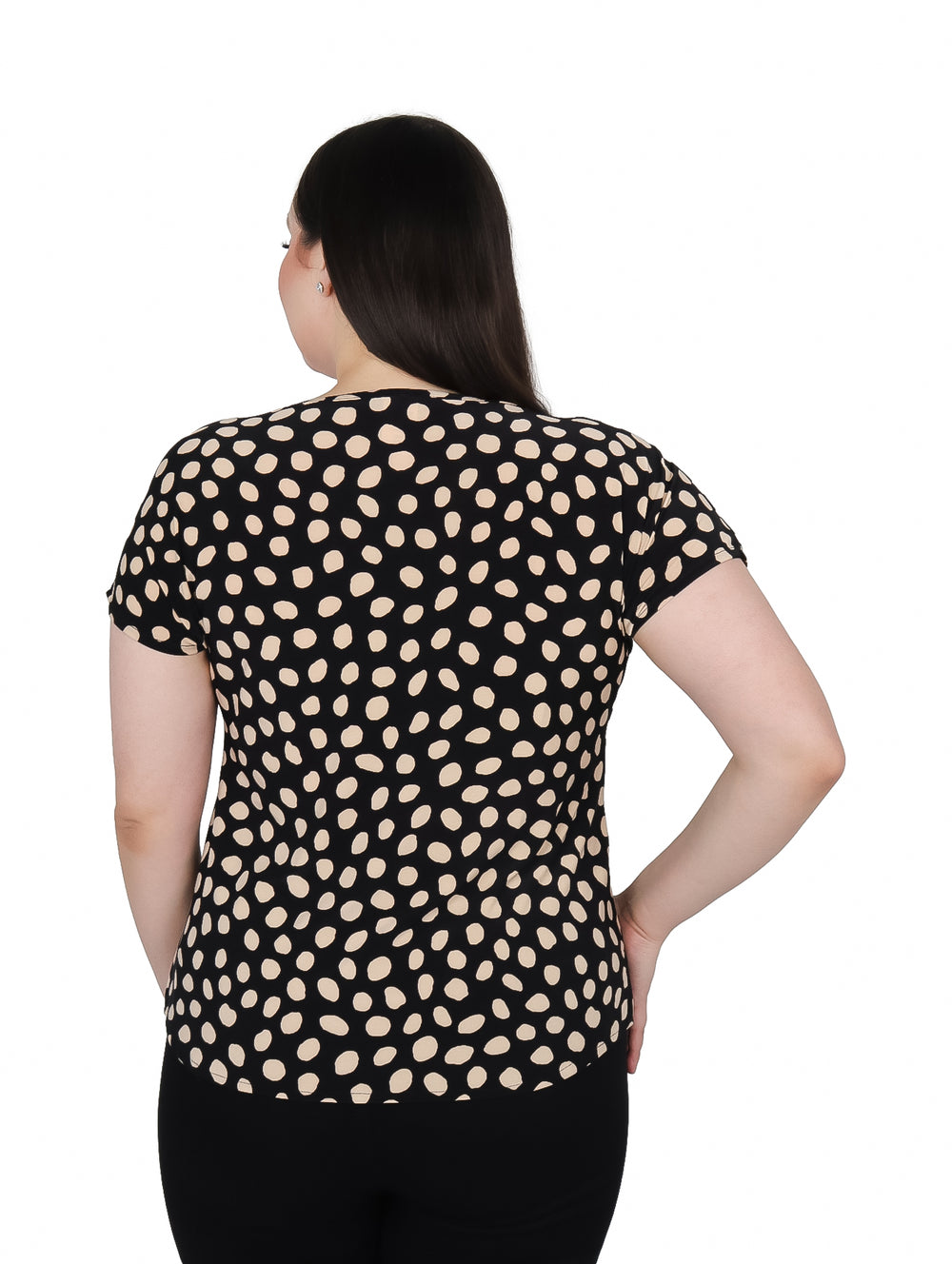 Mujer vistiendo blusa negra con lunares beige y collar dorado desmontable.