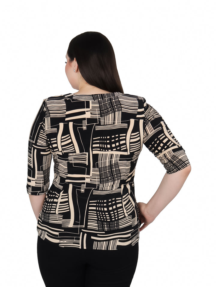 Mujer vistiendo blusa de licra con estampado geométrico en colores negro y beige.