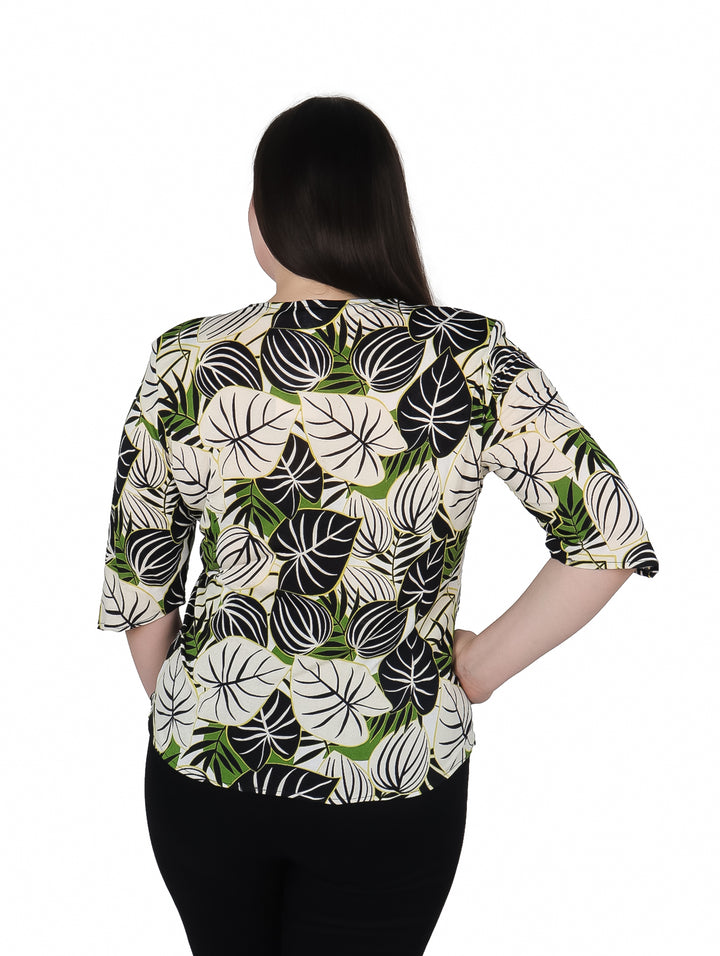 Mujer vistiendo blusa de licra con estampado de hojas en colores verde, blanco y negro.