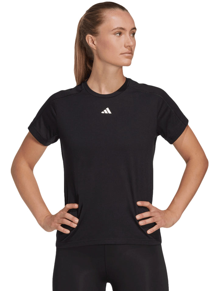 Mujer vistiendo playera deportiva Adidas color negro de manga corta y cuello redondo con logo blanco al centro.