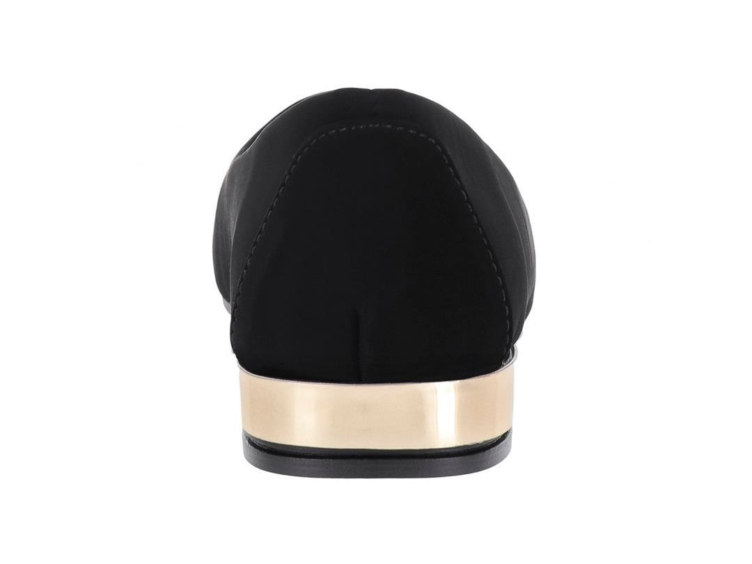 Zapato plano color negro para mujer con un detalle metálico dorado en el talón.