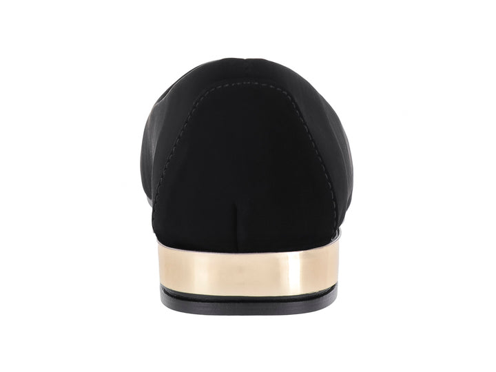 Zapato plano color negro para mujer con un detalle metálico dorado en el talón.