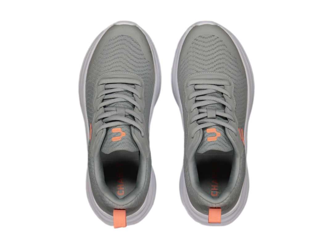 Tenis deportivos Charly color gris con suela blanca y detalles en naranja.