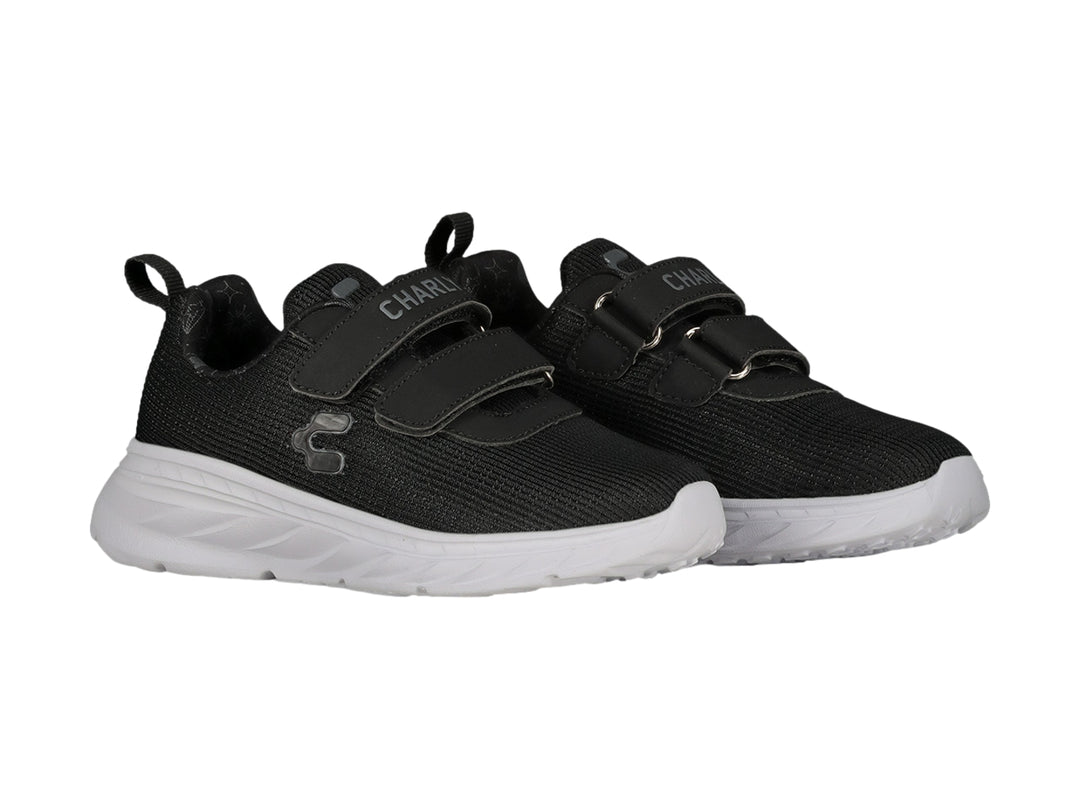 Tenis deportivos Charly color negro con suela blanca y cierres de velcro.