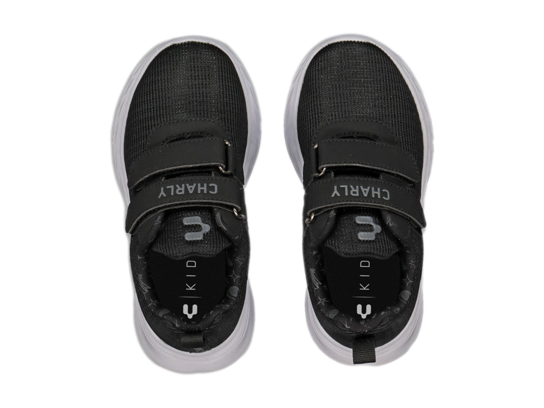 Tenis deportivos Charly color negro con suela blanca y cierres de velcro.