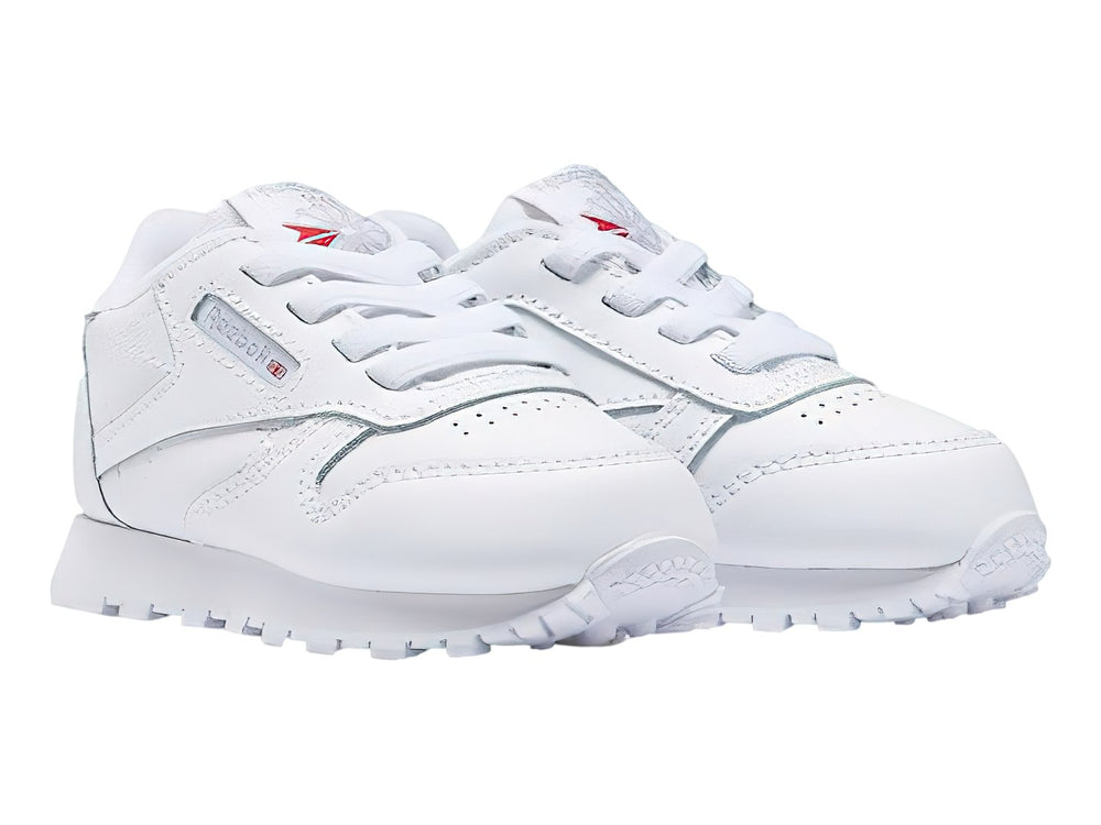 Tenis Reebok Classic Leather en color blanco con suela blanca y cordones.