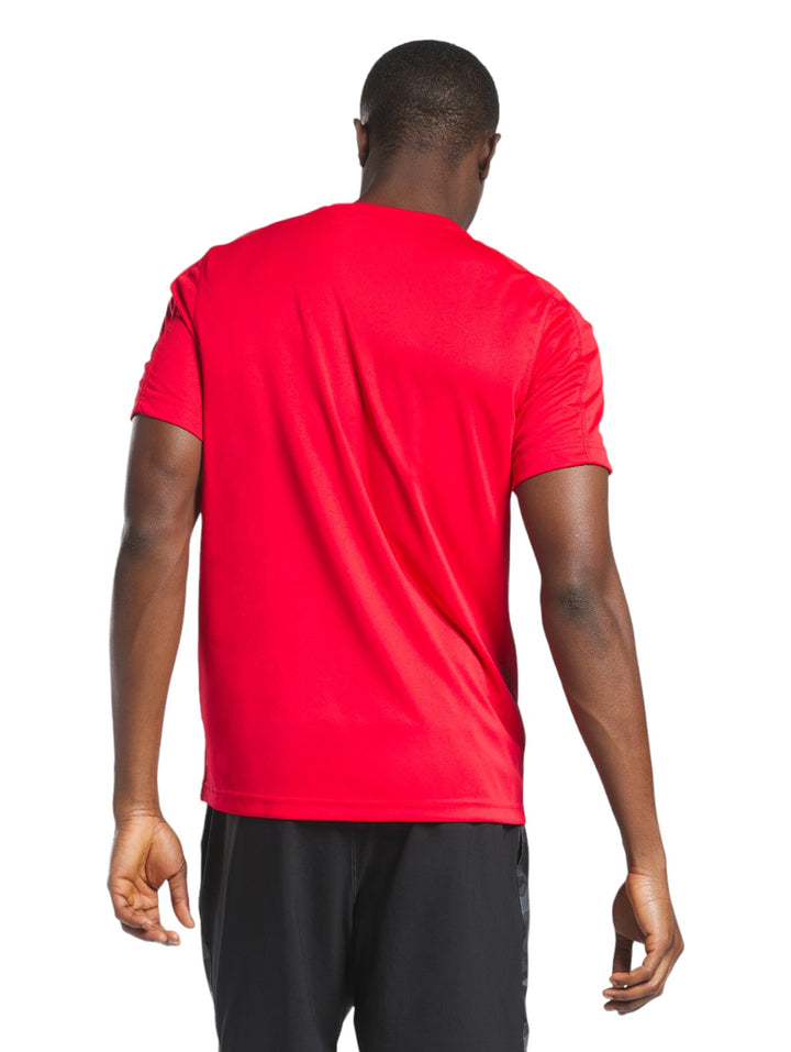 Hombre vistiendo una playera deportiva de manga corta color rojo marca Reebok.