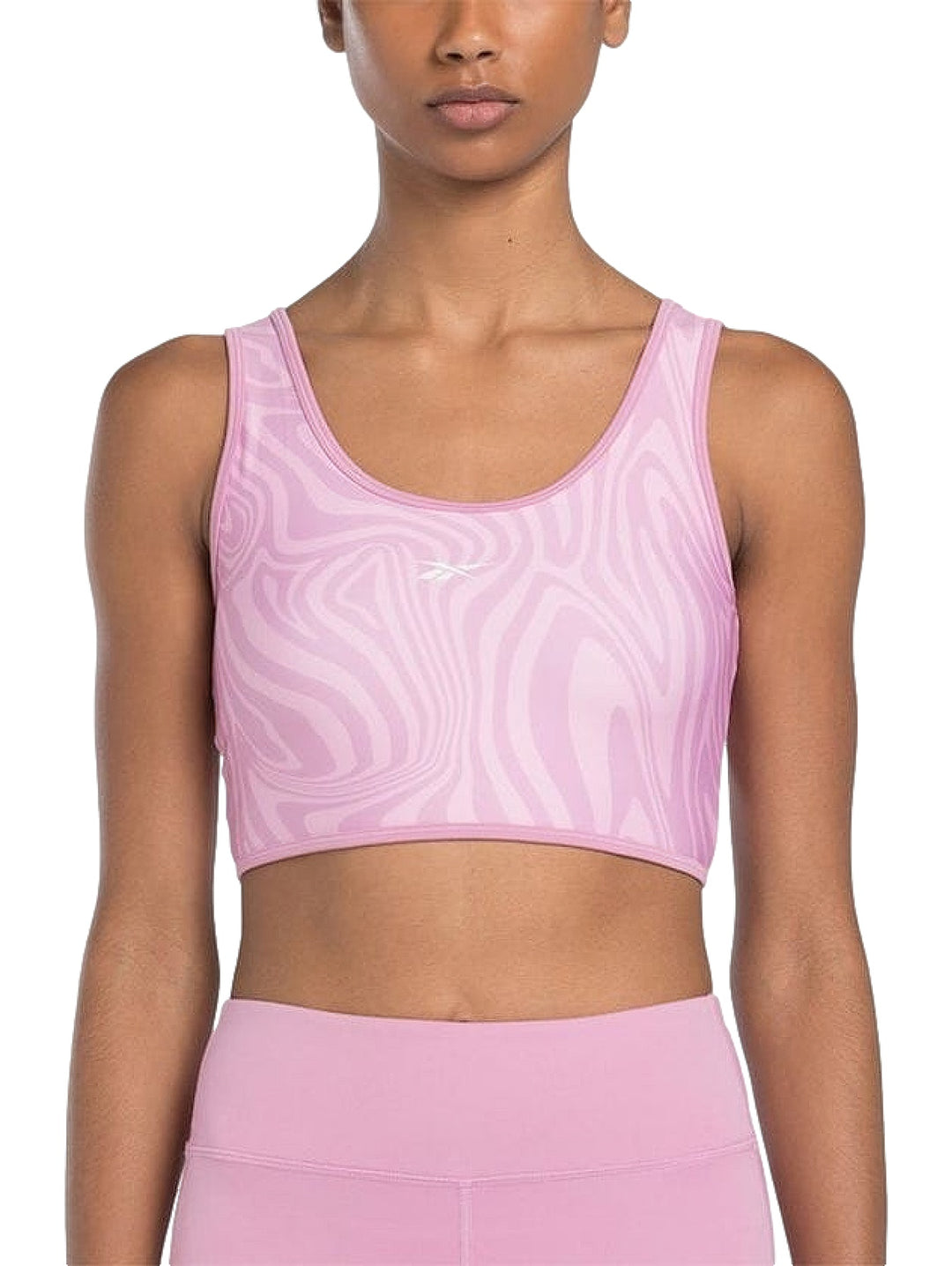 Bralette deportivo Reebok en color rosa con estampado abstracto ondulado y cuello redondo.