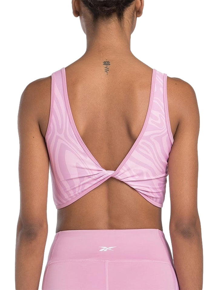Bralette deportivo Reebok en color rosa con estampado abstracto ondulado y cuello redondo.