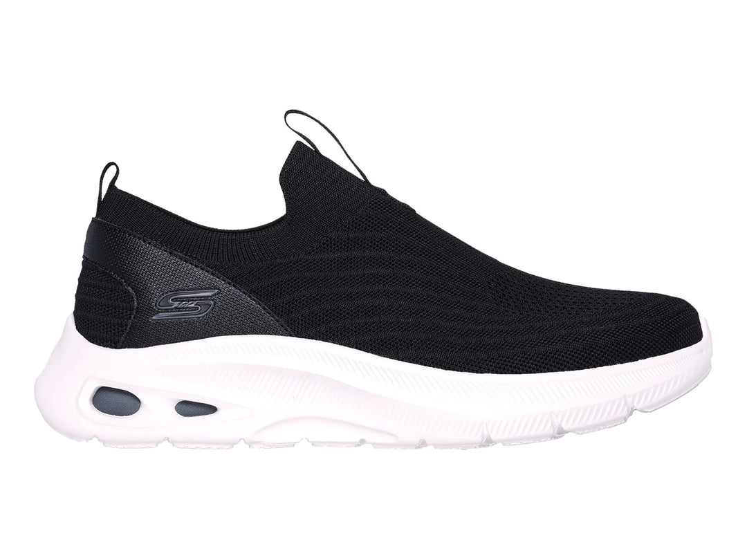 Tenis Skechers negros de tela sin cordones con suela blanca gruesa.