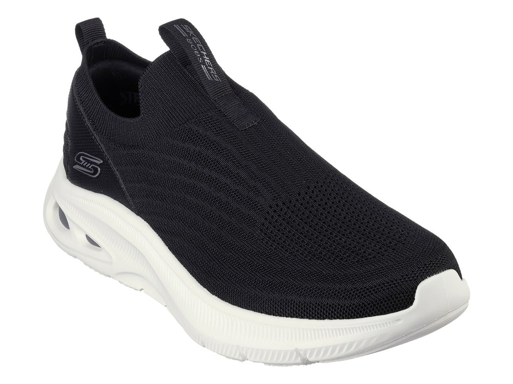 Tenis Skechers negros de tela sin cordones con suela blanca gruesa.