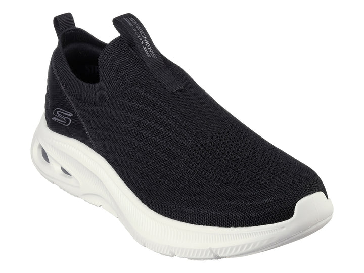 Tenis Skechers negros de tela sin cordones con suela blanca gruesa.