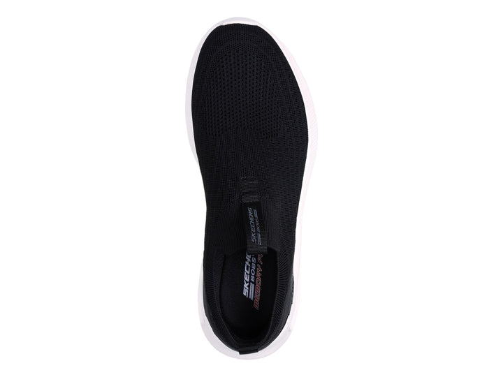 Tenis Skechers negros de tela sin cordones con suela blanca gruesa.