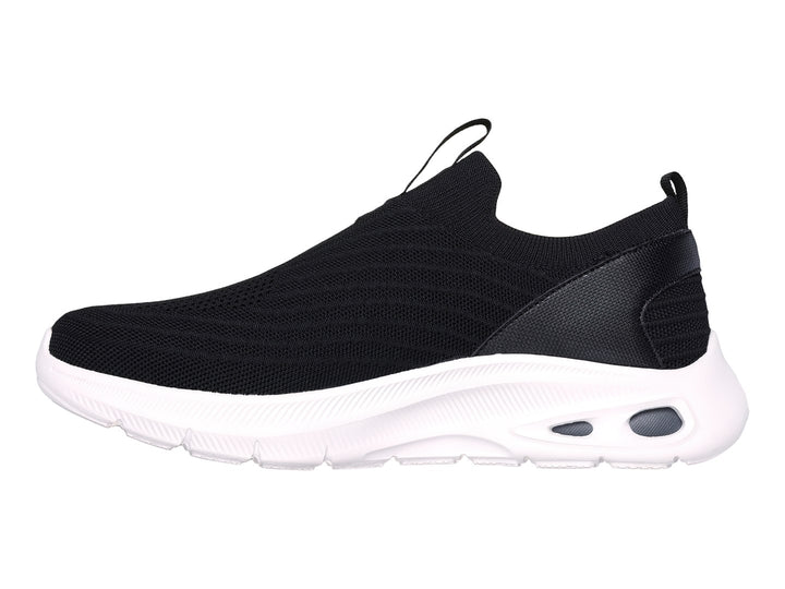 Tenis Skechers negros de tela sin cordones con suela blanca gruesa.